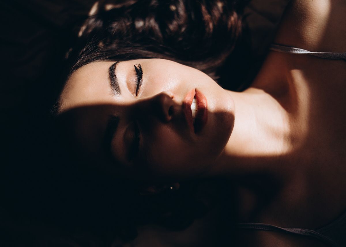 Woman with her eyes closed resting in soft shadow